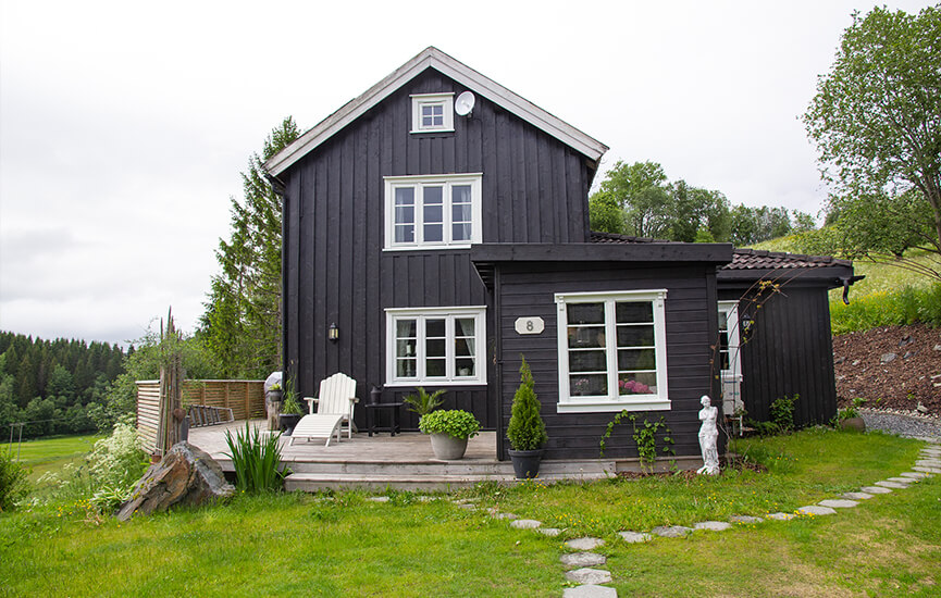 Schwarzes Haus mit weißen Details mit Garten