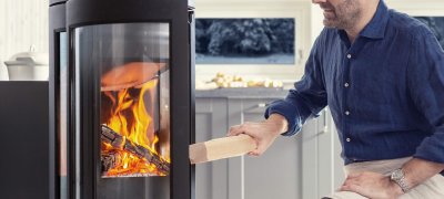 Mann feuert in einem Jøtul-Kamin