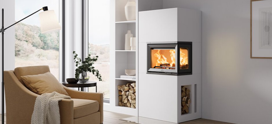Jøtul FS 520 FR wenn Kamin mit Holznische in einem hellen Wohnzimmer mit gelbem Stuhl 