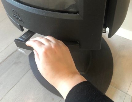 Öffnen Sie die Tür des Holzofens vorsichtig von Hand
