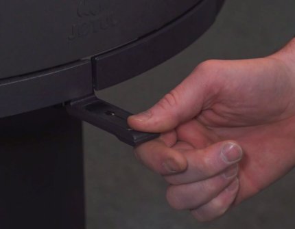 Hand, die die Luftzufuhr im Kamin regelt