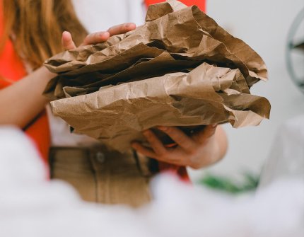Frau, die Pappe in ihren Händen trägt