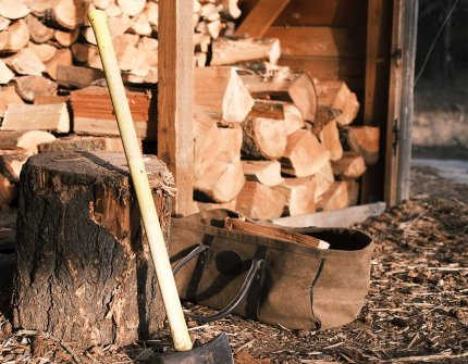 Holz verstecken sich mit Brennholz und Axt 