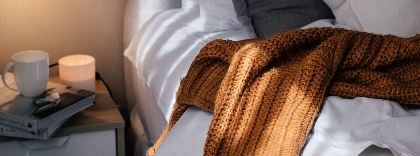 Bett mit Decke und Kaffeetasse